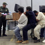 A man has his fingerprints scanned by a U.S. Border Patrol agent while others wait their turn. Photo Credit: Reuters/Jeff Topping